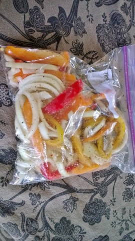 Throw sliced peppers and onions in a bag with oil and seasonings.